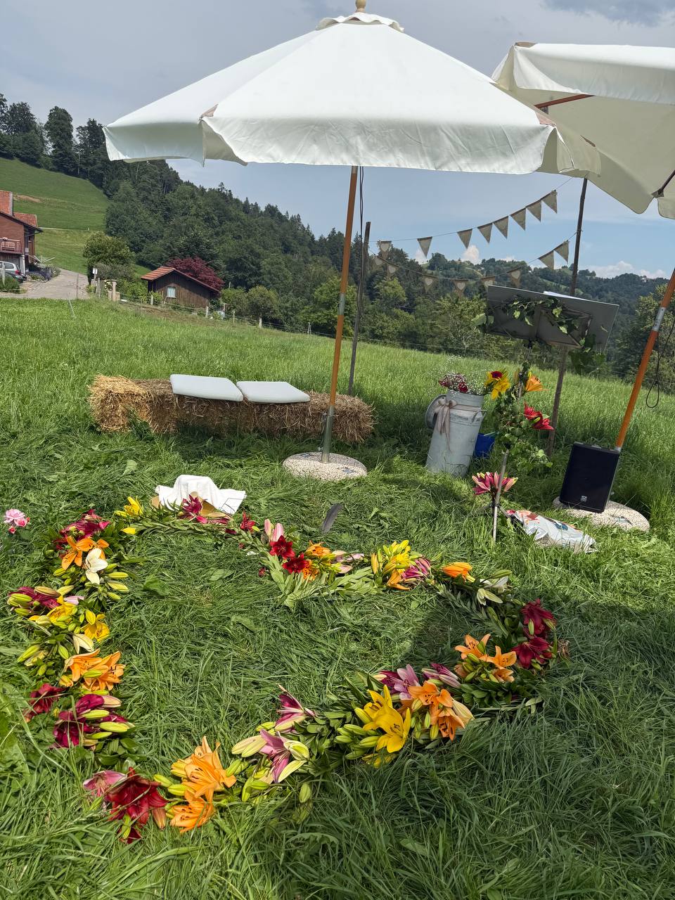 Hochzeit zur Sommersonnenwende 21.6.2026 mit weissen Schirmen, Heuballen und Blumenschmuck im Freien